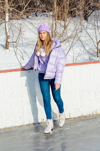 Preciosa joven montando patines de hielo en la pista de hielo . — Foto de Stock