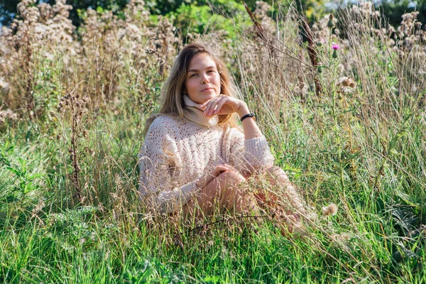 Felice giovane bella donna in maglione e mutande seduta a piedi nudi in un campo di agrimonia secca — Foto Stock