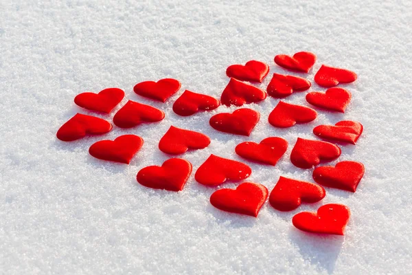 Muitos corações vermelhos em uma forma do grande coração na neve brilhante. Tema do dia de Vilentine . — Fotografia de Stock