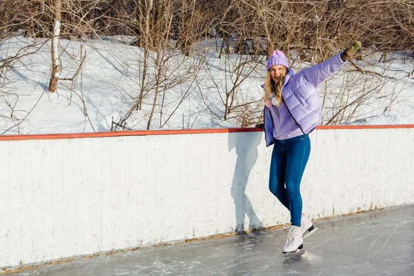 Preciosa joven montando patines de hielo en la pista de hielo . — Foto de Stock