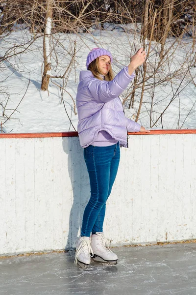 Lovely young woman riding ice skates on the ice rink. — ストック写真