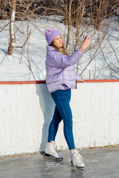 Lovely young woman riding ice skates on the ice rink. — Stock Photo, Image