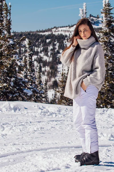 Retrato de una joven hermosa morena con ojos azules y pecas en la cara en invierno nevado paisaje de montaña. Hermosa chica en el invierno al aire libre . — Foto de Stock
