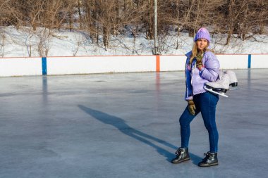 Buz patenleriyle buz pistinde sallanan genç ve güzel bir kadın..