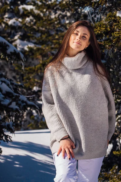 Portrait d'une jeune belle femme brune aux yeux bleus et aux taches de rousseur sur le visage en hiver paysage de montagne enneigé. Belle fille en hiver à l'extérieur debout à côté de l'arbre à fourrure . — Photo