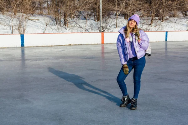 Belle jeune femme avec des patins à glace suspendus sur le cou sur la patinoire . — Photo