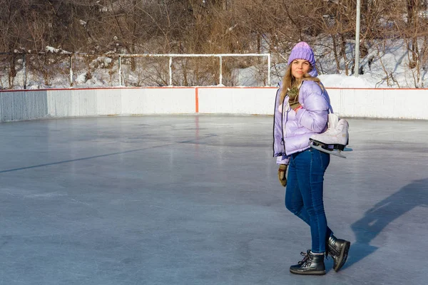 Buz patenleriyle buz pistinde sallanan genç ve güzel bir kadın..