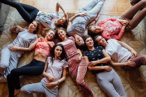 Top view of nine happy beautiful women laying on the floor. — Stock Photo, Image