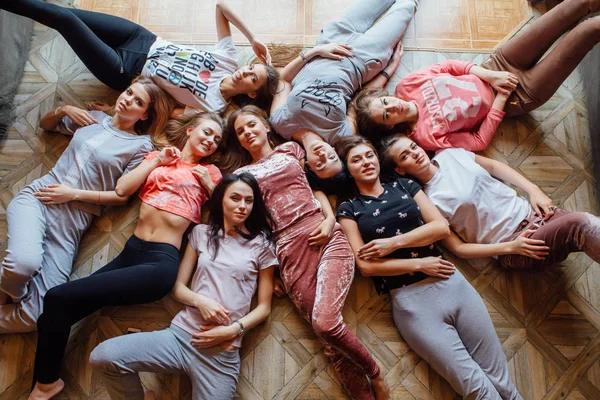 Top view of nine happy beautiful women laying on the floor. — Stock Photo, Image