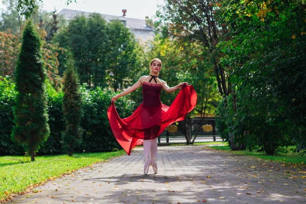 Sonbahar parkında kırmızı bale elbisesiyle dans eden kadın balerin.. — Stok fotoğraf