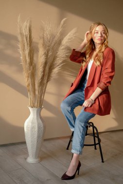 Genç, güzel, sarışın kadın. Pencereden gün ışığında bar sandalyesinde oturuyor.