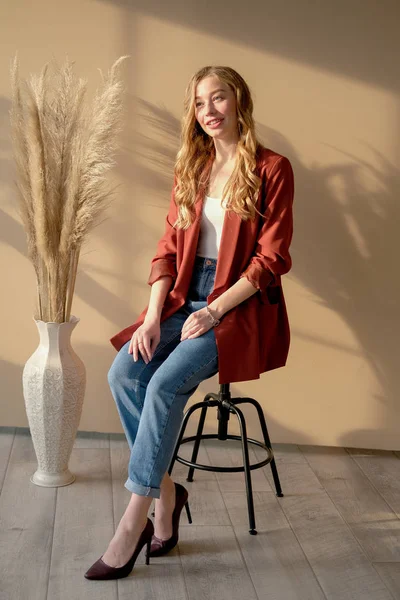 Joven mujer rubia hermosa sentada en una silla de bar a la luz del día desde la ventana — Foto de Stock