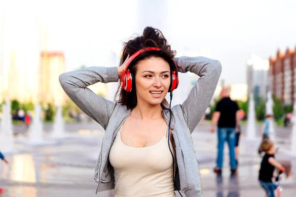 Girl listening to music streaming with headphones and making funny face.