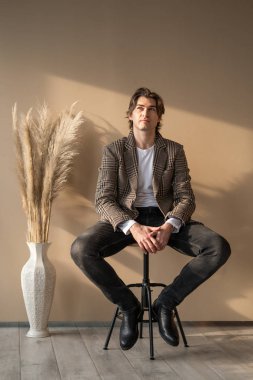 Pencereden gün ışığında bar sandalyesinde oturan uzun boylu yakışıklı adam.