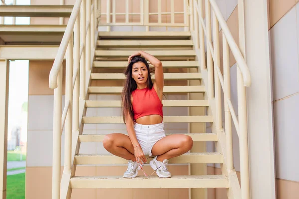 Rua moda verão retrato de uma mulher sentada em escadas ao ar livre . — Fotografia de Stock