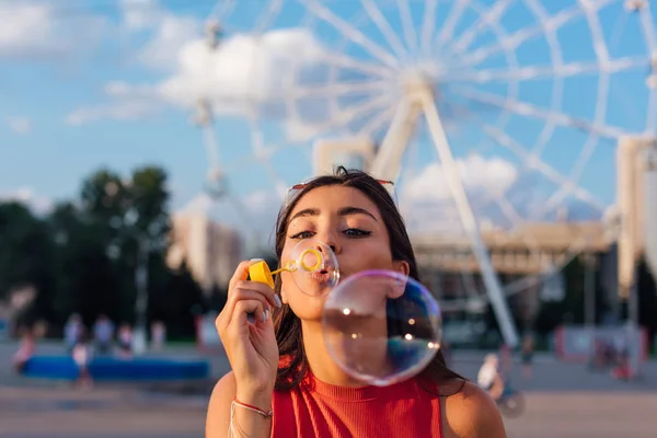 Vacker ung kvinna blåser såpbubblor utomhus — Stockfoto