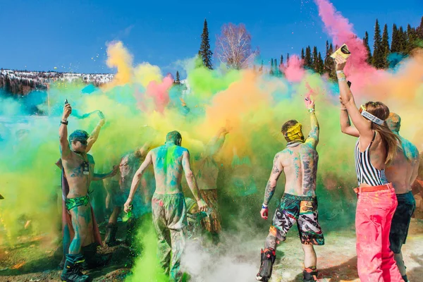 Sheregesh, región de Kemerovo, Rusia - 13 de abril de 2019: Un grupo de jóvenes lanzando coloridos holis en polvo . — Foto de Stock