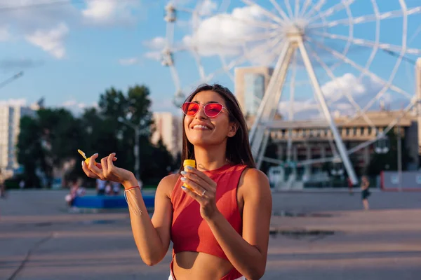 Mulher bonita soprando bolhas de sabão ao ar livre — Fotografia de Stock