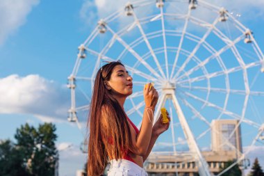 güzel bir genç kadın açık havada sabun köpüğü üfleme