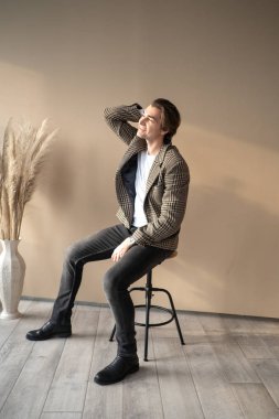 Pencereden gün ışığında bar sandalyesinde oturan uzun boylu yakışıklı adam.