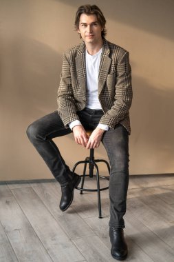 Pencereden gün ışığında bar sandalyesinde oturan uzun boylu yakışıklı adam.