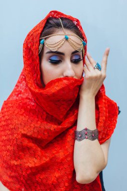 Parlak makyajlı ve kırmızı başörtüsü takan güzel bir doğu kadınının portresi..