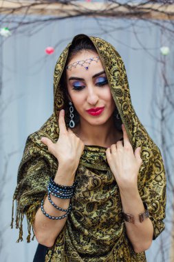 Parlak makyajlı ve başörtüsü takan güzel bir doğu kadınının portresini yakından çek..