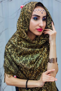 Parlak makyajlı ve başörtüsü takan güzel bir doğu kadınının portresini yakından çek..