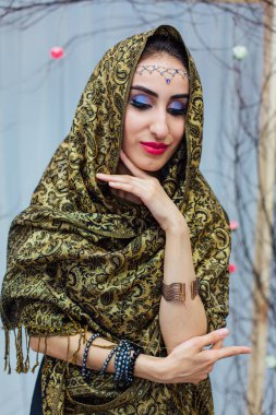 Parlak makyajlı ve başörtüsü takan güzel bir doğu kadınının portresini yakından çek..