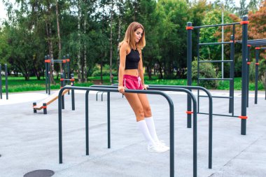 Sen dışarıda egzersiz yapan güzel sarışın bir kadınsın. Antrenman yerinde.