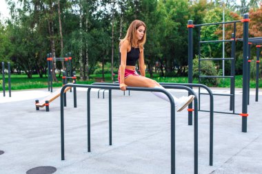 Sen dışarıda egzersiz yapan güzel sarışın bir kadınsın. Antrenman yerinde.