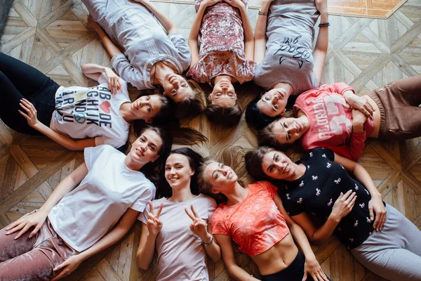 Top pohled na devět šťastné krásné ženy ležící na podlaze. — Stock fotografie