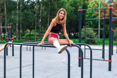 Genç, güzel, sarışın bir kadın akşam egzersizinden sonra dinleniyor.