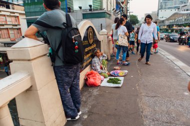 Bangkok, Tayland - 13 Şubat 2018: Yürüme yolunda oturan Taylandlı kadın farklı şeyler satıyor. Bangkok 'ta asfaltta oturan bir sokak satıcısı.