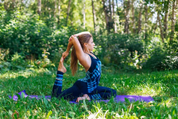 Beyaz bir kadın yaz kenti parkında yoga egzersizleri yapıyor..