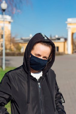 Siyah kumaş maskeli beyaz bir kadın. Coronavirus COVID-19 gibi mikropların yayılmasını önlemek için tıbbi maske kullanma kavramı.