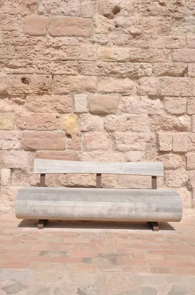 Wooden bench against a stone wall — Stock Photo, Image