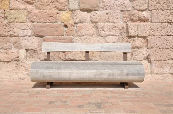 Wooden bench against a stone wall — Stock Photo, Image