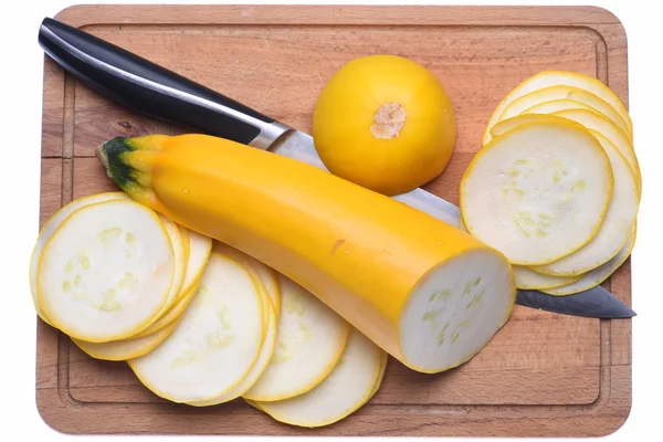 Zucchini in Scheiben geschnitten und Messer auf einem Holzbrett — Stockfoto