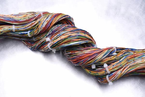 Tourbillon de câbles électriques colorés sur fond métallique — Photo