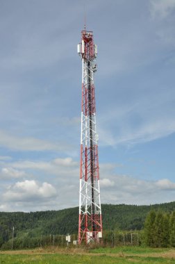 İletişim kulesi bulutlu gökyüzü karşı bir tepe üzerinde