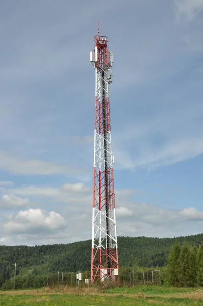 İletişim kulesi bulutlu gökyüzü karşı bir tepe üzerinde