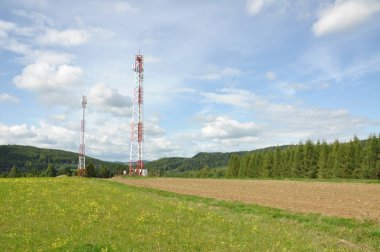 İletişim kulesi bulutlu gökyüzü karşı bir tepe üzerinde