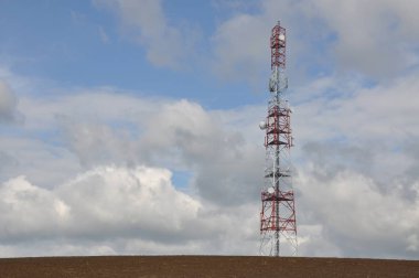 İletişim kulesi bulutlu gökyüzü karşı bir tepe üzerinde