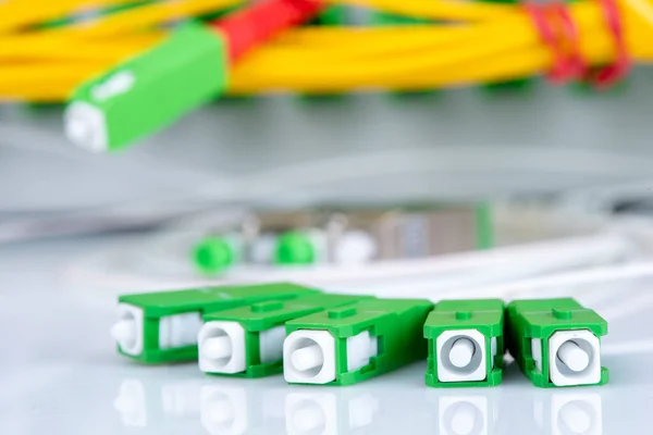 Fiber optic connectors closeup and distribution frame in background