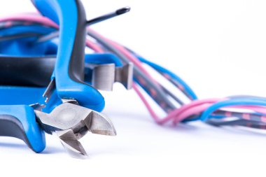 Beyaz arkaplanda izole edilmiş elektrik kurulumunda kullanılan renkli kablolar ve araç penseleri