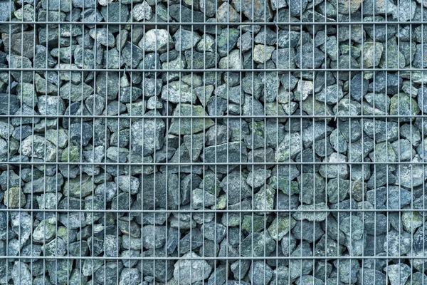 Retaining wall made of stacked stone-filled gabion tied together with wire, natural background