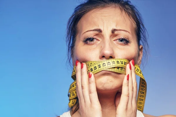 Vrouw met een gelaste tape op de lippen. Ze is bezorgd over het dieet. — Stockfoto