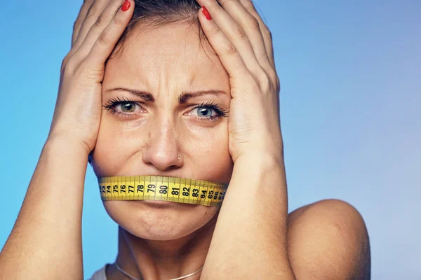 Mujer con una cinta adhesiva en los labios. Ella está preocupada por la dieta . —  Fotos de Stock