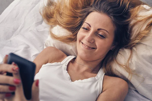 Jeune femme en mauvais regardant son téléphone — Photo